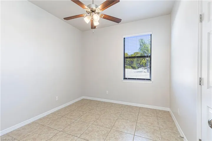 Unfurnished room featuring light tile patterned floors and ceiling fan