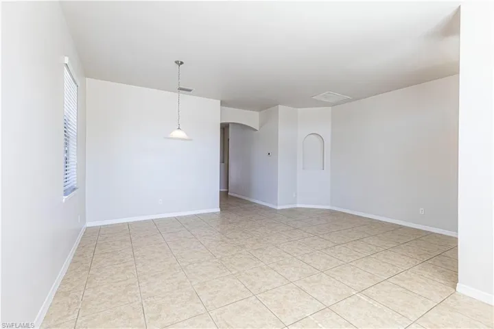 Spare room with arched walkways and light tile patterned floors