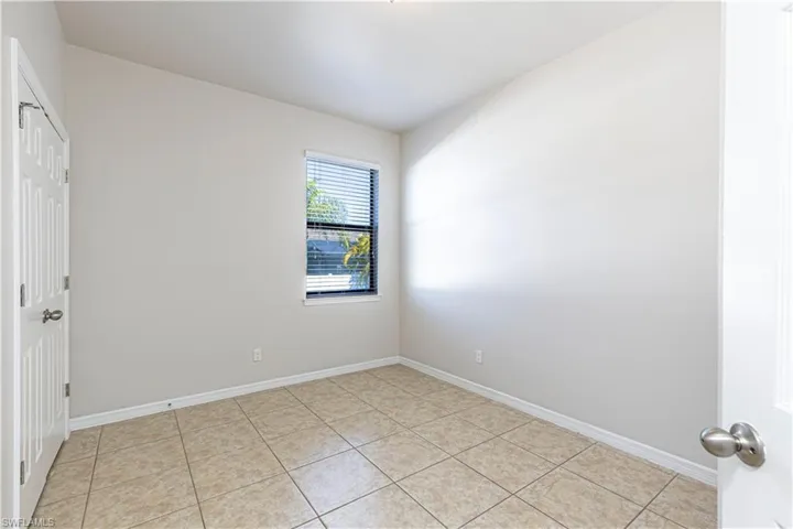 Unfurnished bedroom with a closet and light tile patterned flooring