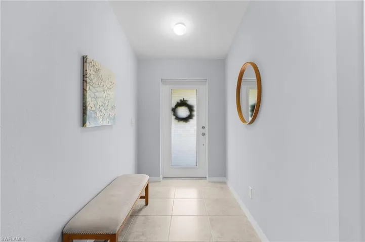 Doorway featuring baseboards and light tile patterned floors