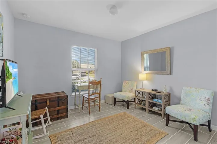Living area with baseboards and tiled floor