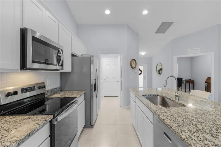 Kitchen featuring appliances with stainless steel finishes, visible vents, a sink, and decorative backsplash