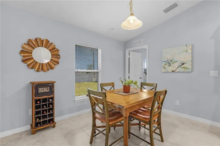 Dining area with lofted ceiling, visible vents, and baseboards