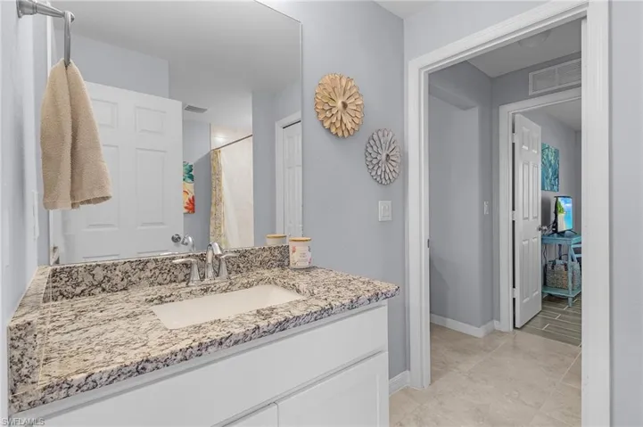 Bathroom with baseboards, visible vents, vanity, and a shower with shower curtain