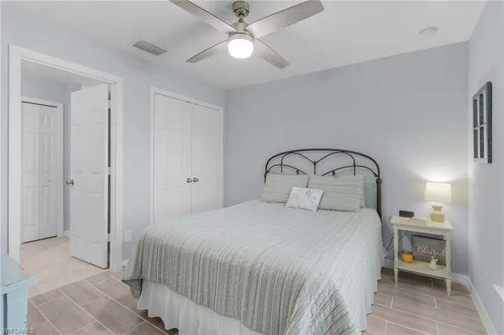 Bedroom with baseboards, visible vents, and a ceiling fan