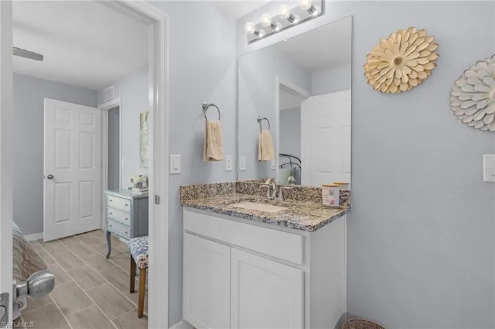 Bathroom with visible vents, vanity, and baseboards
