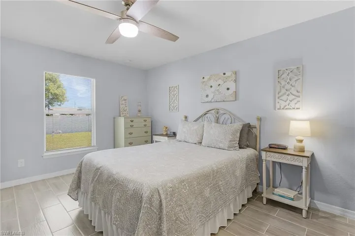 Bedroom with tile floors, a ceiling fan, and baseboards