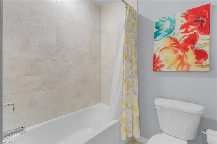 Bathroom with shower / bath combo with shower curtain and toilet