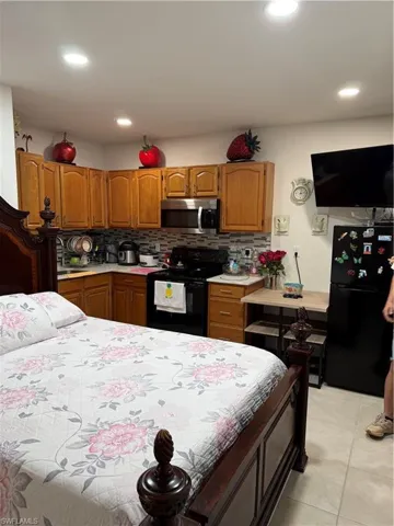 Bedroom featuring refrigerator, recessed lighting, and light tile patterned flooring