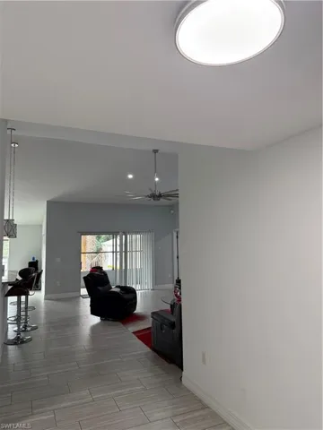Living room featuring wood tiled floors, a ceiling fan, and recessed lighting
