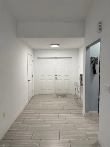 Corridor with baseboards and wood tiled floors