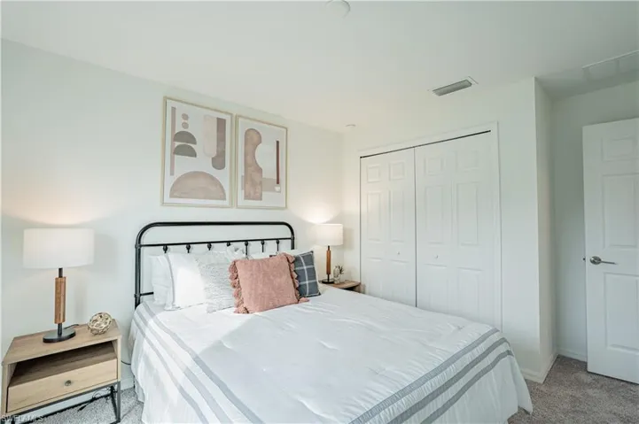 Carpeted bedroom featuring a closet and baseboards
