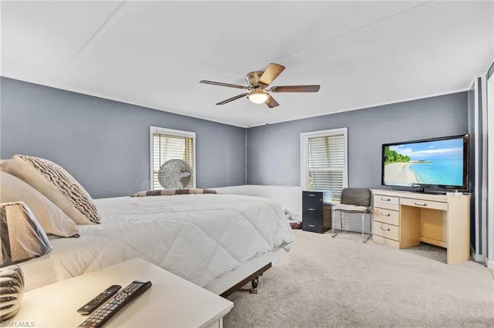 Carpeted bedroom featuring a ceiling fan
