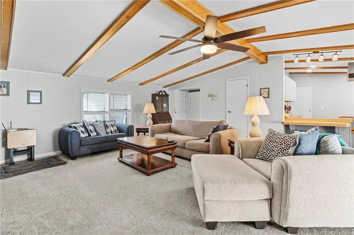Carpeted living room with ceiling fan.