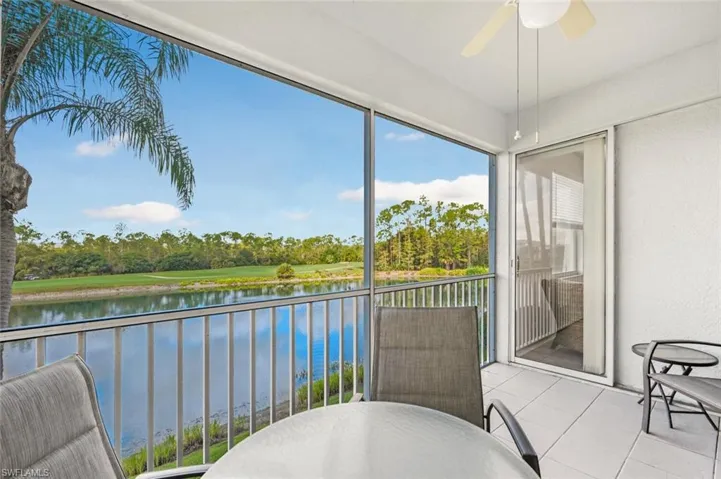 Sunroom / solarium with a water view and view of scattered trees