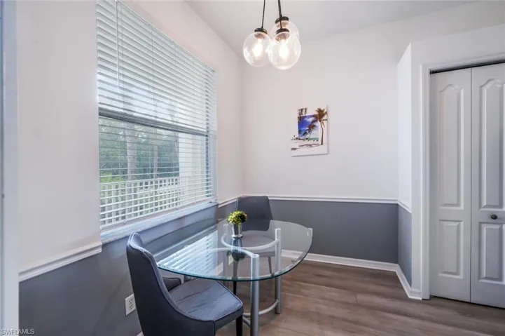 Dining area with dark wood-type flooring and a chandelier