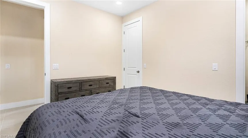 Unfurnished bedroom featuring light tile patterned floors and baseboards