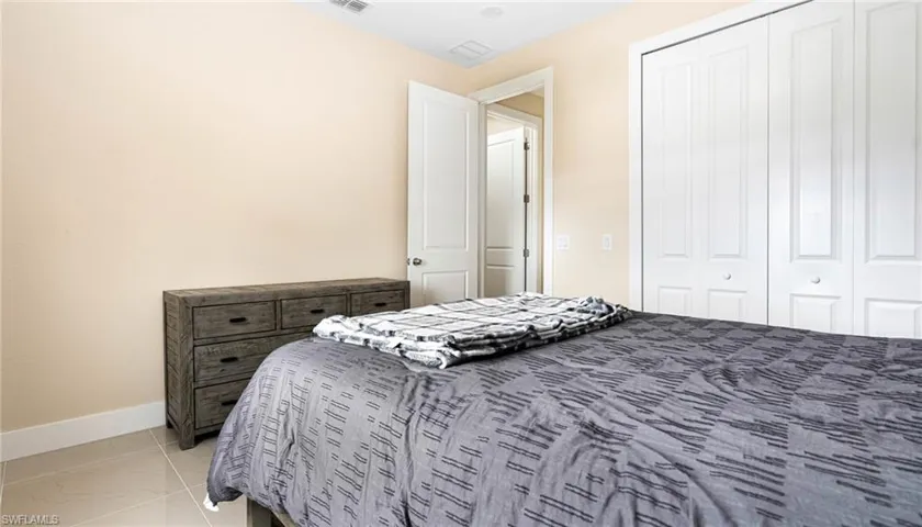 Bedroom featuring visible vents, baseboards, and a closet