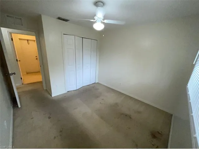 Unfurnished bedroom with ceiling fan, a closet, and carpet floors