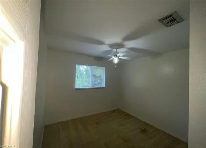 Empty room with carpet flooring and ceiling fan