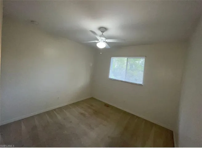 Carpeted spare room featuring ceiling fan
