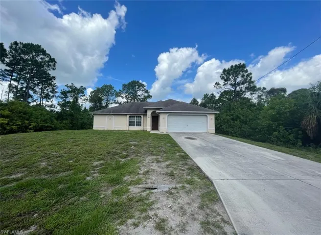 View of front facade with a garage and a front lawn