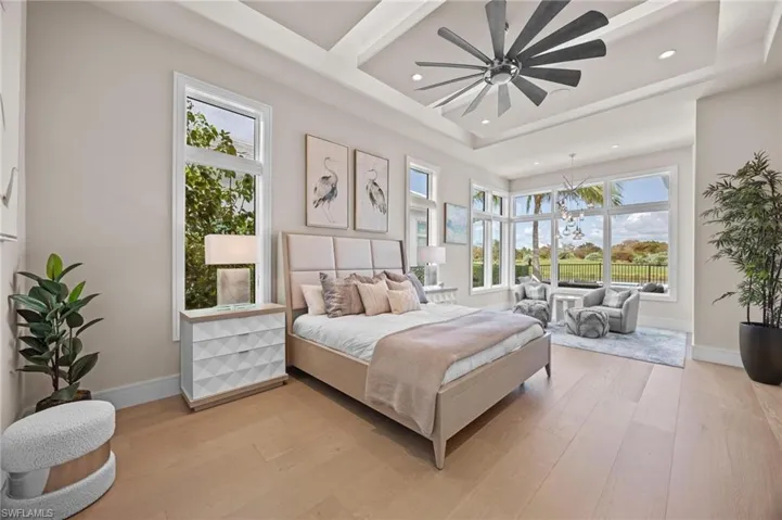 Bedroom featuring multiple windows, light hardwood / wood-style floors, and ceiling fan