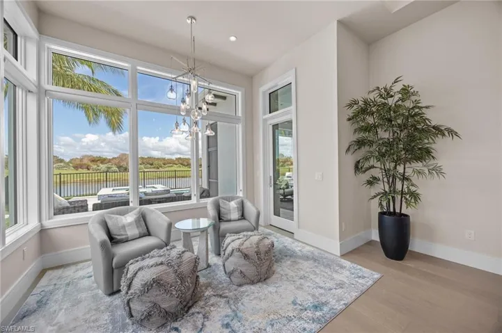 Living area featuring a chandelier, light hardwood / wood-style flooring, and a water view