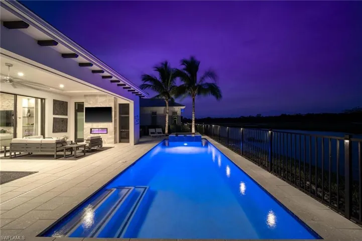 Pool at dusk with a patio and an outdoor living space