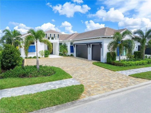 View of front facade featuring a three car garage w high ceiling