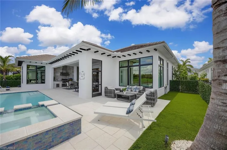 Back of property with a patio area, a pool with hot tub, and an outdoor hangout area