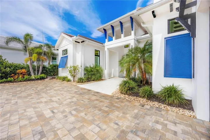 Front with large pavered driveway