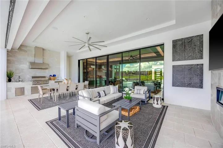 Tiled living room featuring tile walls and ceiling fan
