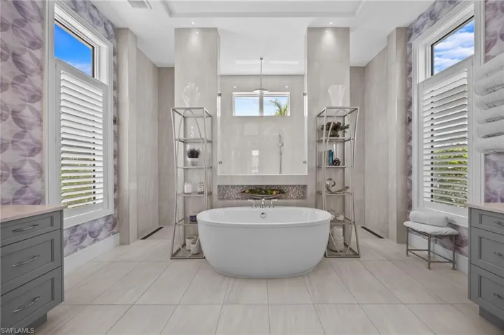Bathroom with vanity, tile walls, and plenty of natural light