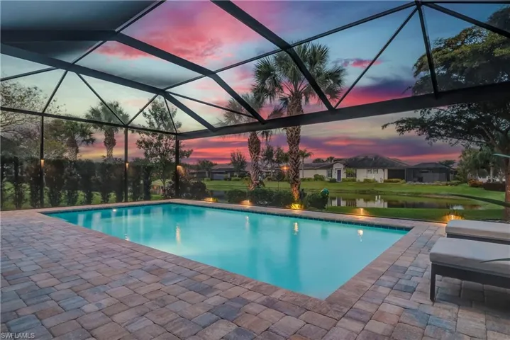 Outdoor pool featuring panoramic water views, lush landscape, and lighting