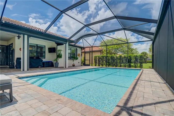 Outdoor pool featuring a lanai, a patio area, and a sunroom