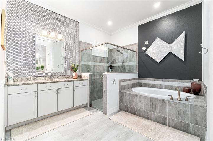 The primary bath offers a custom tiled tub for relaxation, and a roomy walk-in shower.  The custom tile above the vanities offers a modern twist to the entire space.