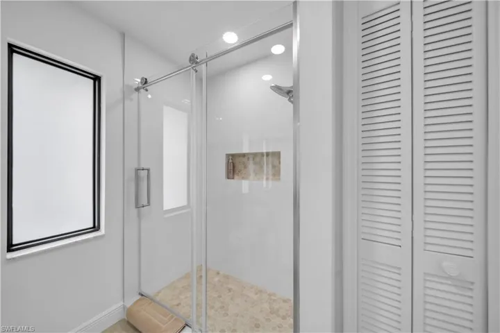 Full bathroom with a closet and a stall shower