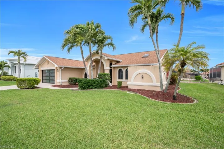 Mediterranean / spanish-style home with a garage, stucco siding, driveway, a front lawn, and a shingled roof