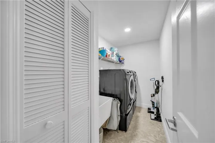Laundry room with recessed lighting and washer and dryer