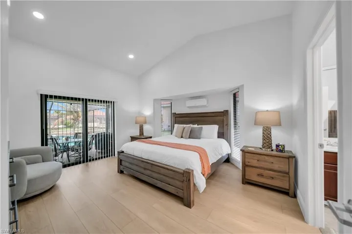 Bedroom with access to outside, lofted ceiling, recessed lighting, and light wood finished floors