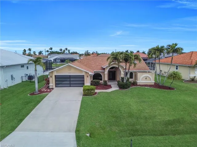 Mediterranean / spanish-style house with stucco siding, a front lawn, driveway, a garage, and a shingled roof