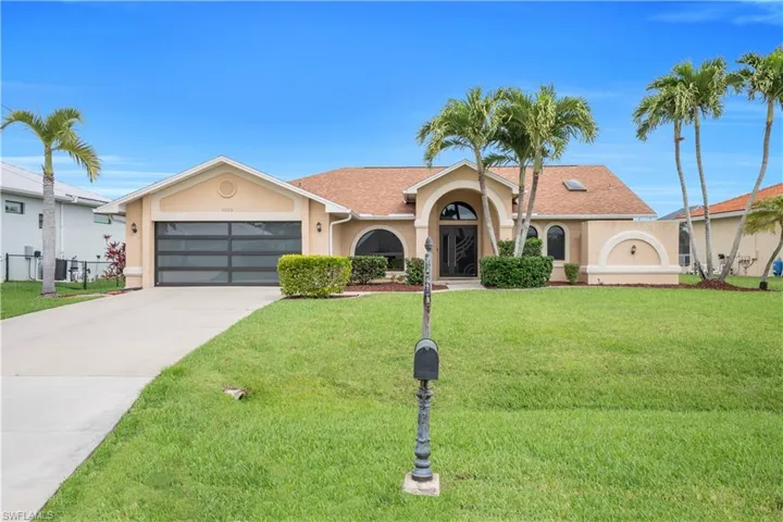 Ranch-style house with stucco siding, a garage, driveway, and a front yard