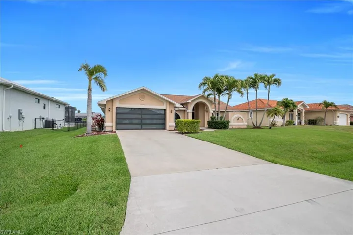 Single story home with a front yard, a garage, stucco siding, and driveway
