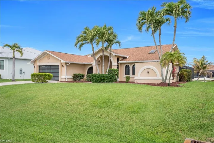 View of front of home featuring stucco siding, a front lawn, and an attached garage
