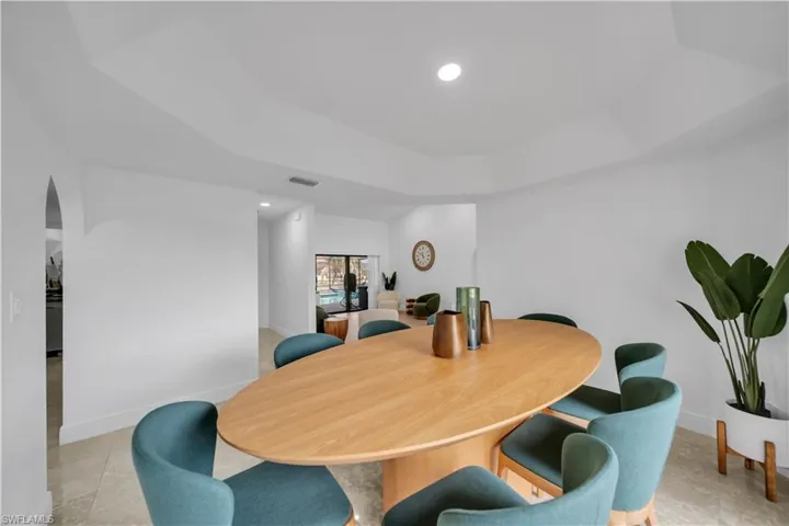 Dining room with recessed lighting, a raised ceiling, and arched walkways