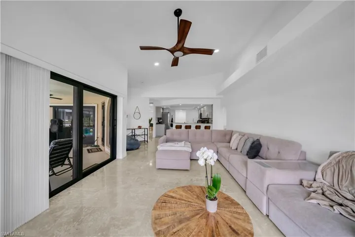 Living area with a ceiling fan, recessed lighting, and lofted ceiling