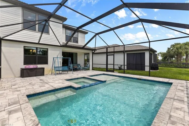 View of swimming pool with a patio, a lanai, and an in ground hot tub
