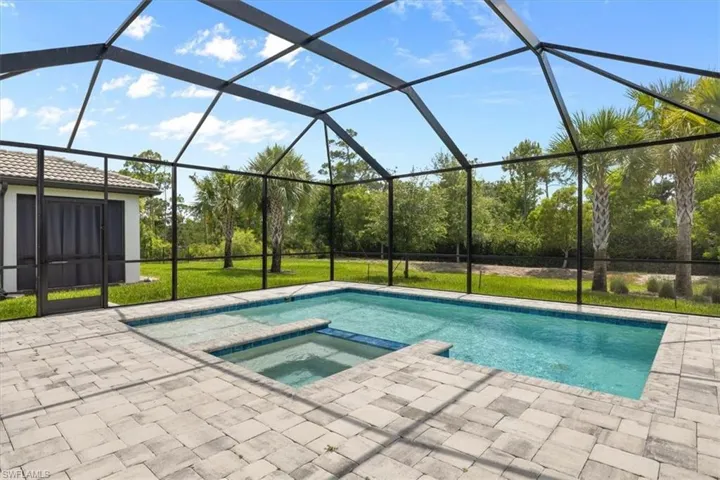 View of swimming pool featuring an in ground hot tub, a lanai, and a patio area