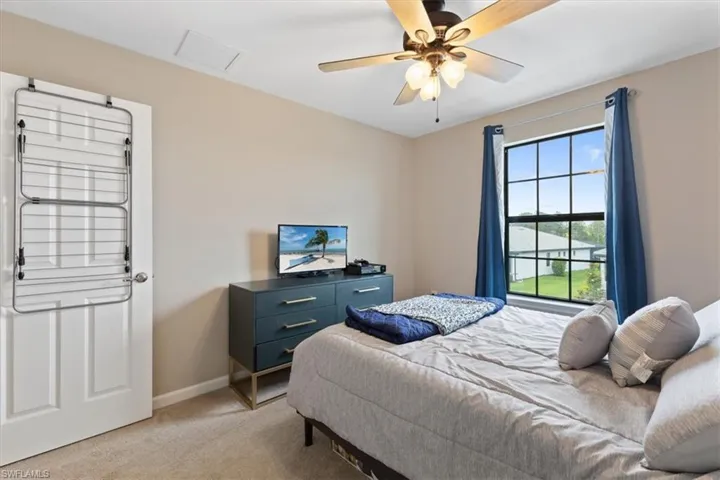 Carpeted bedroom featuring ceiling fan
